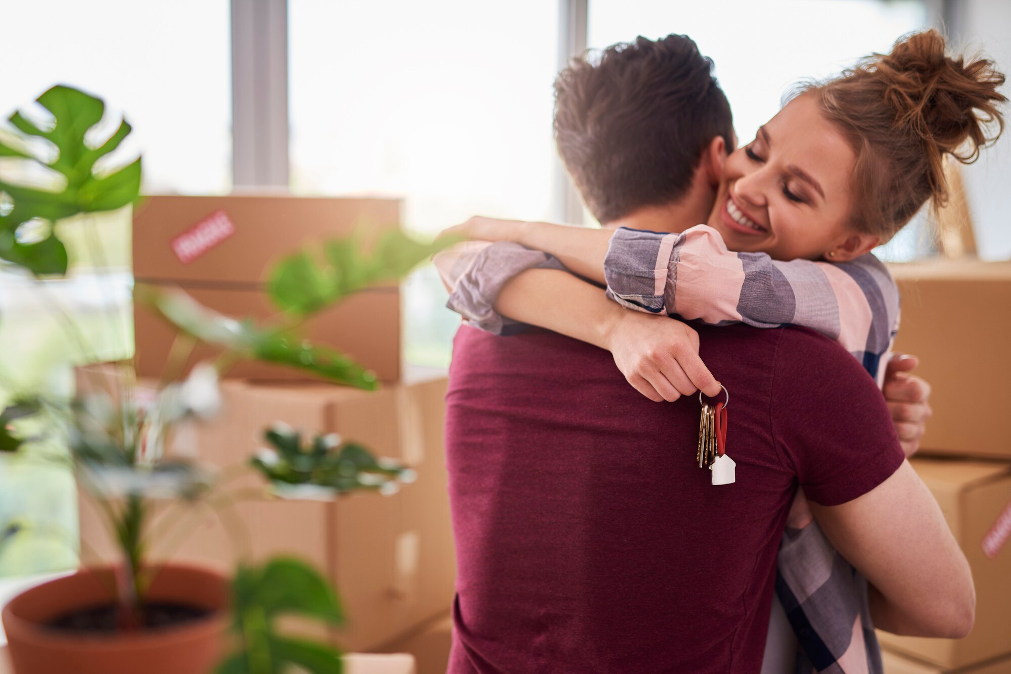 Happy couple hugging with keys